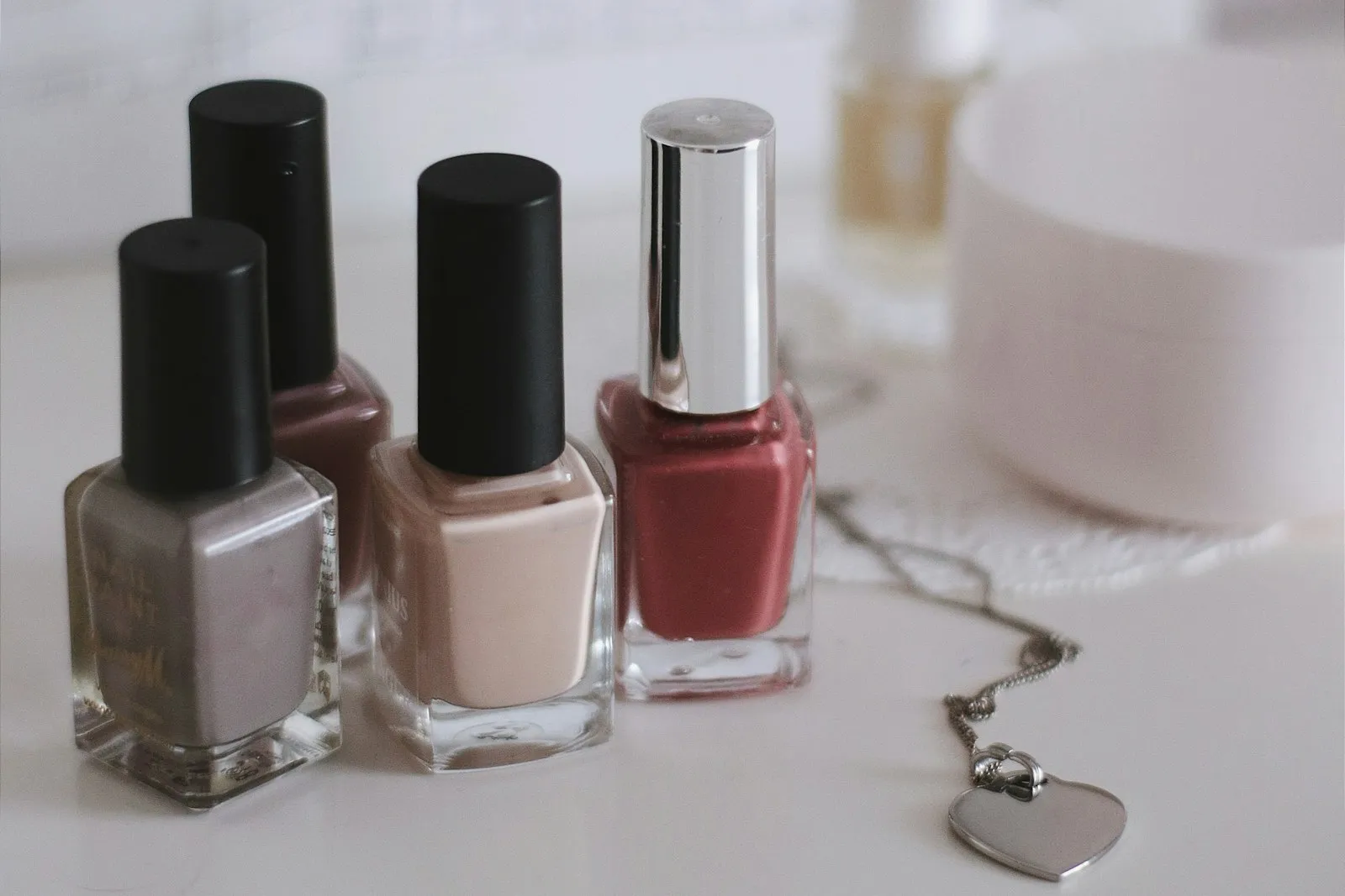 Pink and black nail polish bottles on a plain background